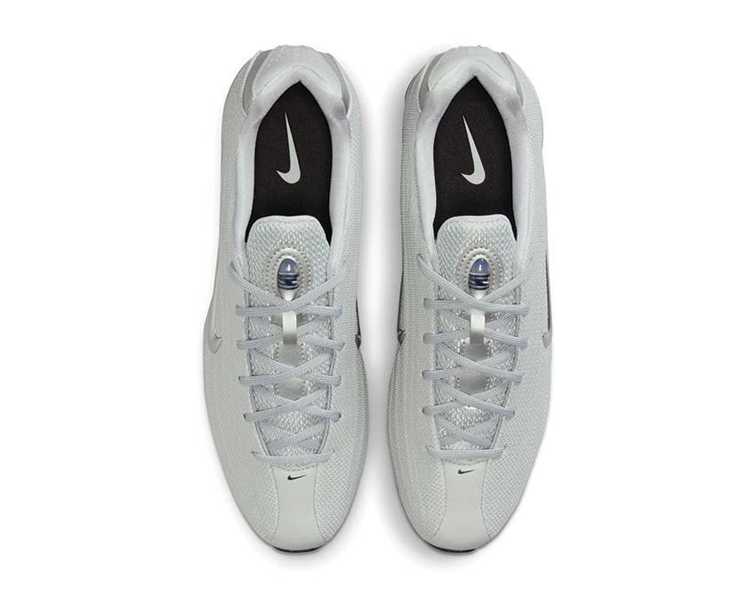 Scarpe sportive argentate con sistema di ammortizzazione a colonne.