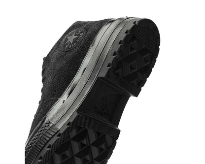 Calzatura alta in tela nera con suola in gomma e stile retrò anni '70.