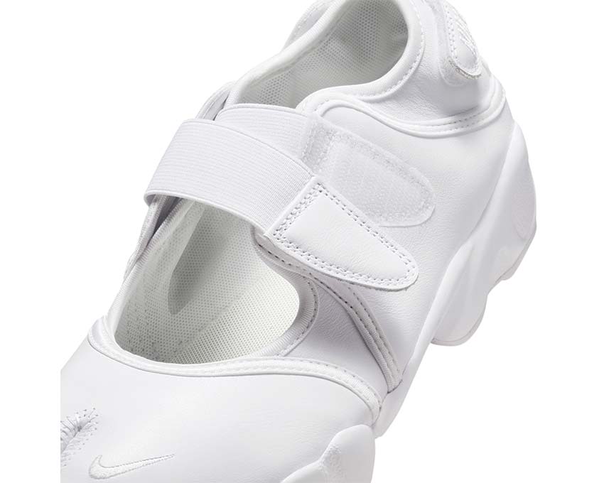 Scarpa da ginnastica femminile in tessuto bianco con struttura aperta.