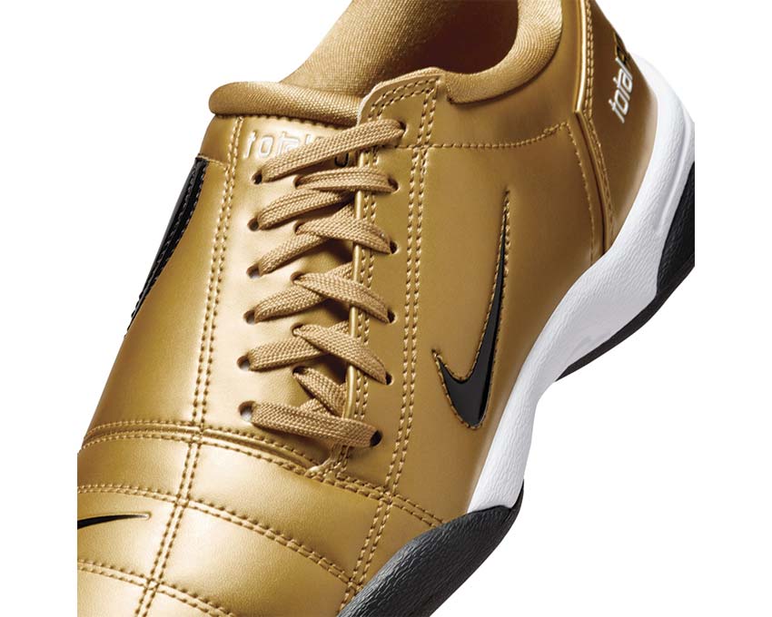 Calzature sportive in pelle sintetica color oro metallizzato.
